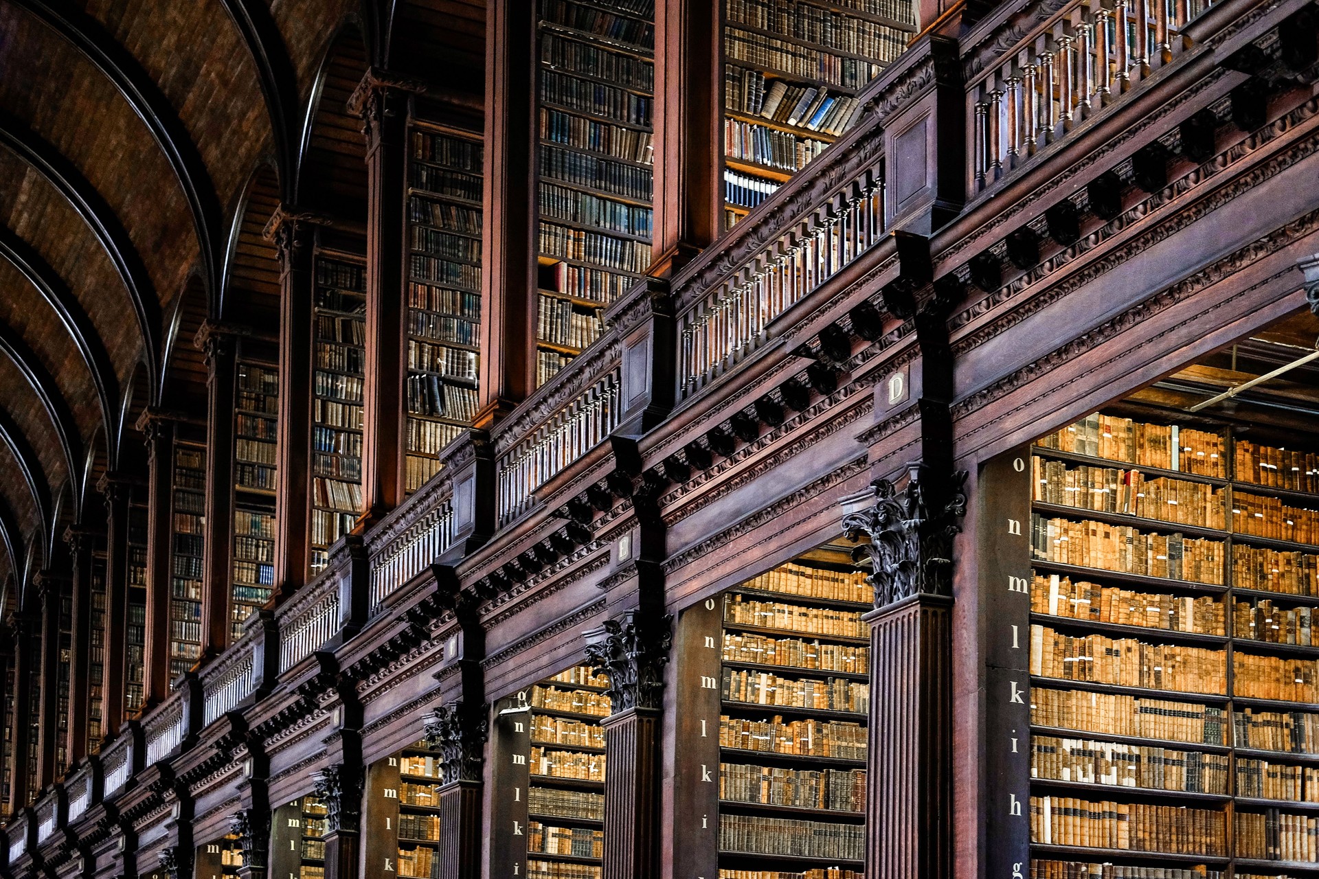 Low angle view of books on shelves in Long Room of Trinity College Old Library in Dublin.